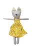 Stuffed toy cat in a yellow dress on a kitchen counter