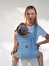 Woman holding a baby in a blue baby carrier
