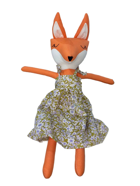 Stuffed fox toy wearing a floral dress on a white background