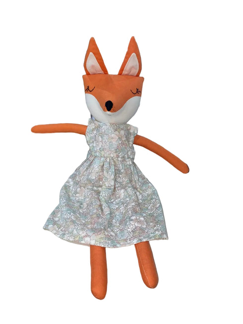 Stuffed fox toy with a floral dress on a white background
