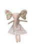 Stuffed animal toy with floral ears and a white dress with pink polka dots on a light surface.
