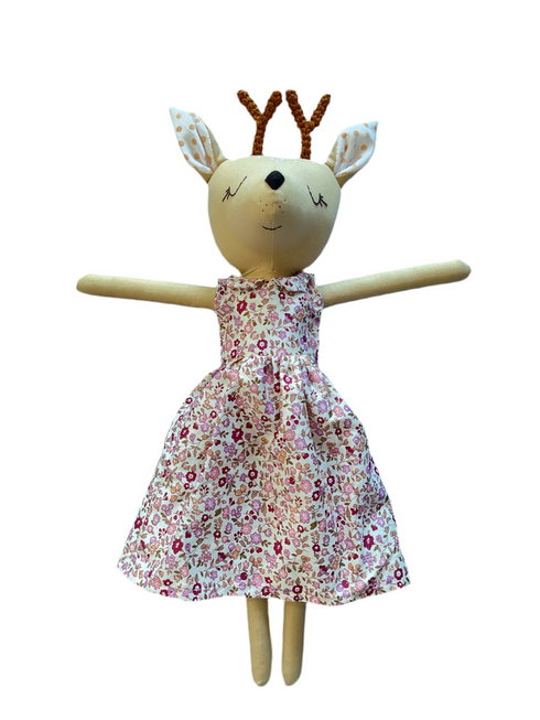 Stuffed toy deer with a pink dress on a white background