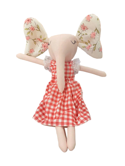 Doll with floral ears and a red checkered dress on a white surface
