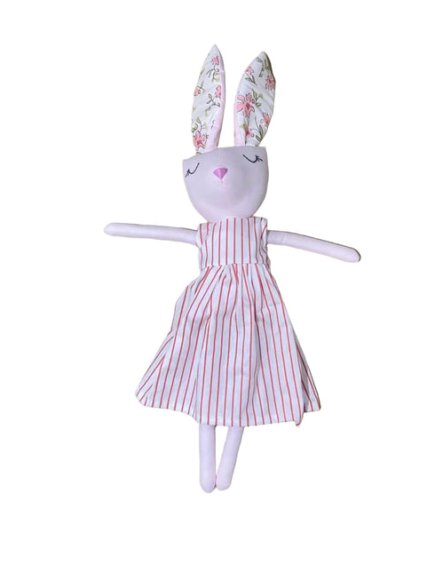 Small plush toy with a striped dress on a wooden surface