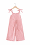Pink jumpsuit with bow straps on a hanger against a white background