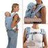Woman using a blue baby carrier with detachable hood and chest clip features.