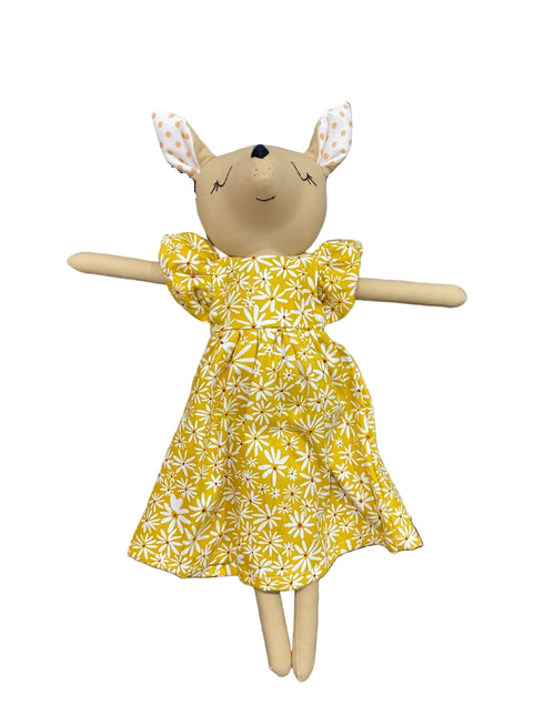 Toy deer wearing a yellow floral dress on a white background
