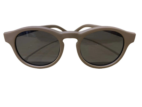 Beige sunglasses with dark lenses on a light wooden surface