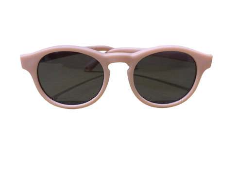 Pink sunglasses on a light wooden surface with a blurred background