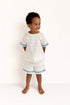 Child wearing a white crochet outfit with blue trim on a white background