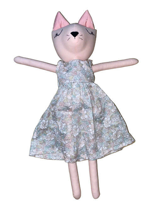Stuffed animal cat wearing a floral dress on a white background