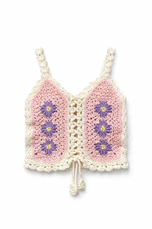 Crocheted pink and white top with floral patterns on a white background