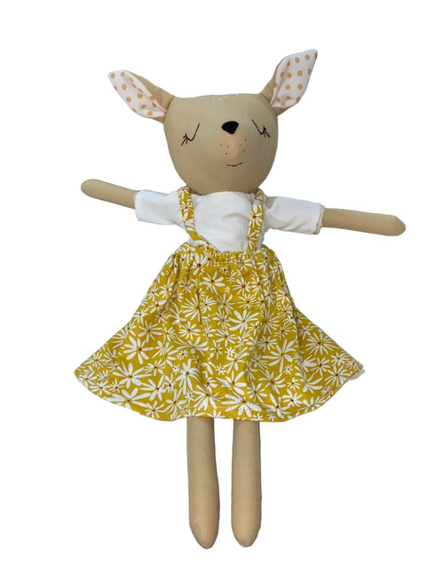 Toy deer with a yellow floral dress on a white background