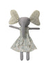 Gray elephant plush toy with a floral dress on a light surface.