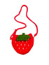 Crocheted strawberry-shaped purse on a dark surface with a notebook and pen in the background.