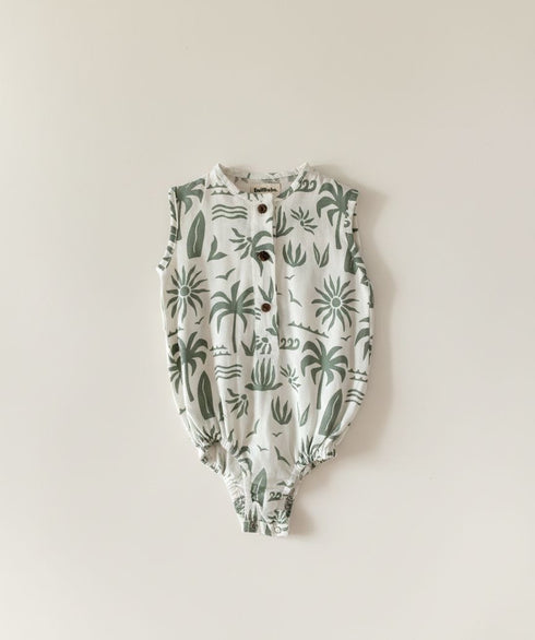 Baby romper with green plant pattern on a beige background